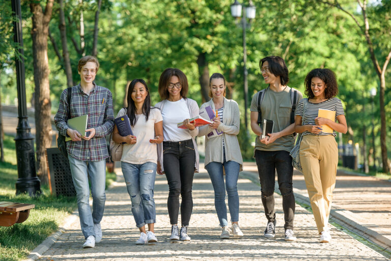 Young happy students walking while talking. Looking aside