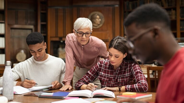 University students studying with teacher